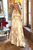 Katya Wildman in a full length gold and cream dress