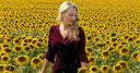 Katya in a velvet dress standing in a field of sunflowers